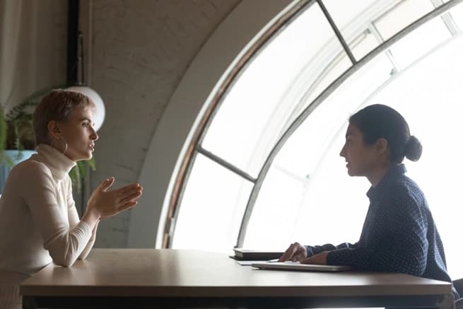 two women taking at a table