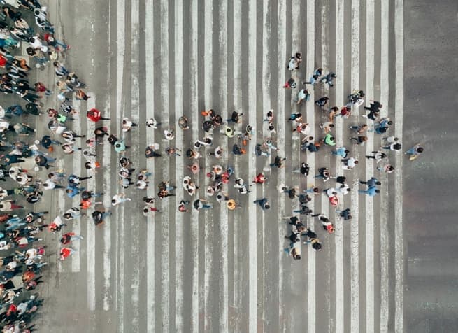 arrow made of people on crosswalk 