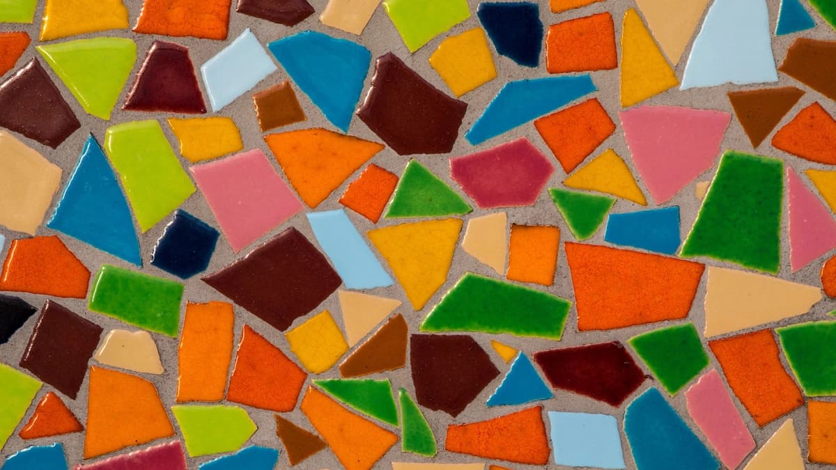 close up view of a colorful mosaic of broken pieces in a brown wall