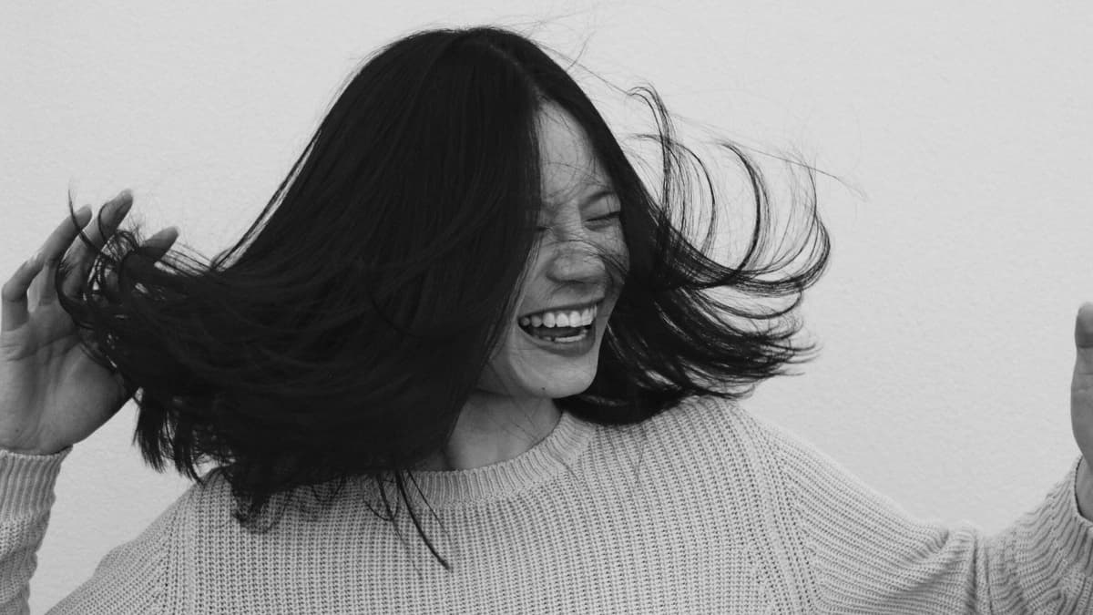 woman laughing, her hair blowing in wind