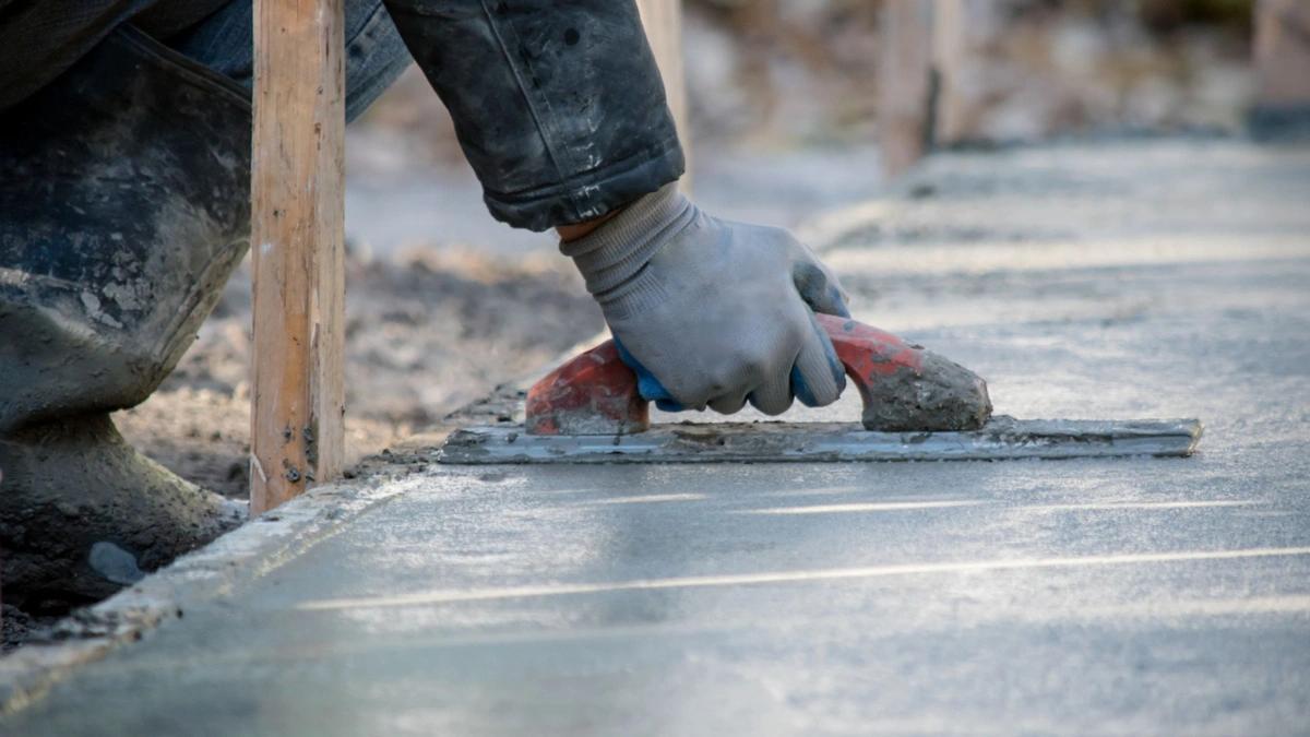 hand building a foundation with concrete 