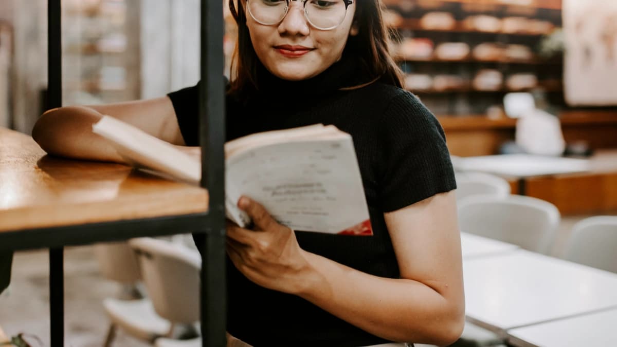 estudiante escogiendo un libro de una estantería de la biblioteca