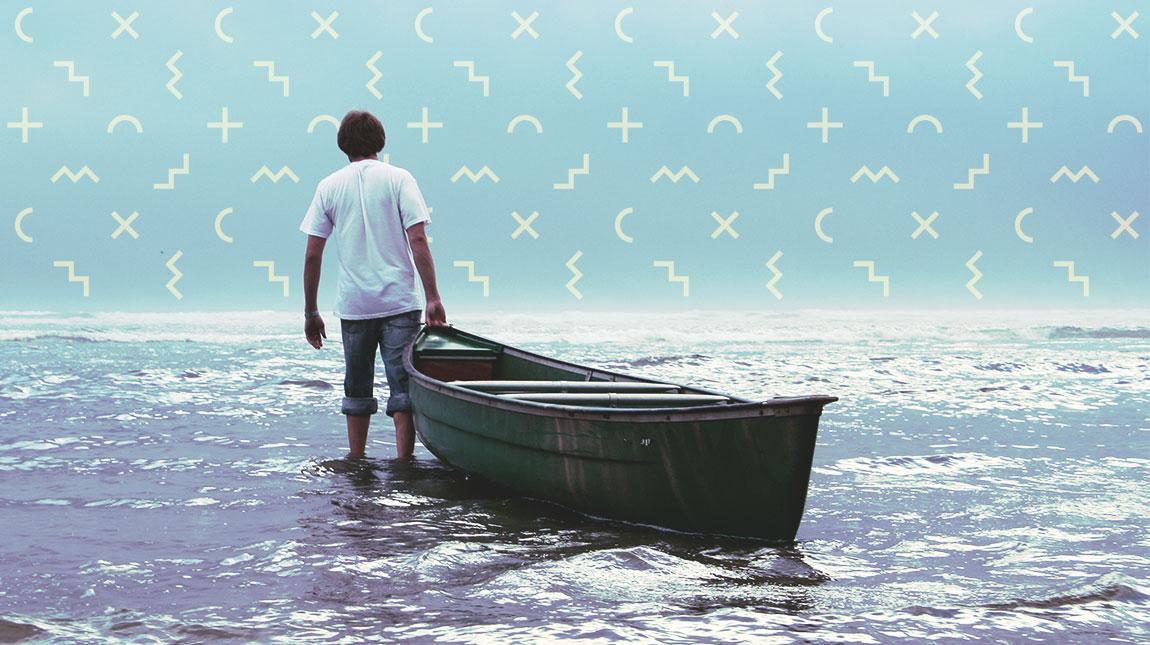 teenage boy pulling a small boat in the water