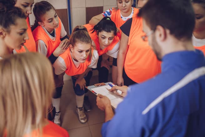 soccer team gathering around coach